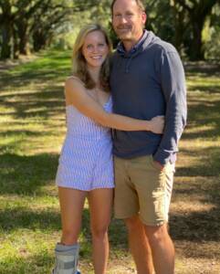 Whitney Heins wearing a boot standing with her husband