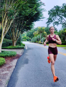 Whitney Heins running in a red Tracksmith outfit.