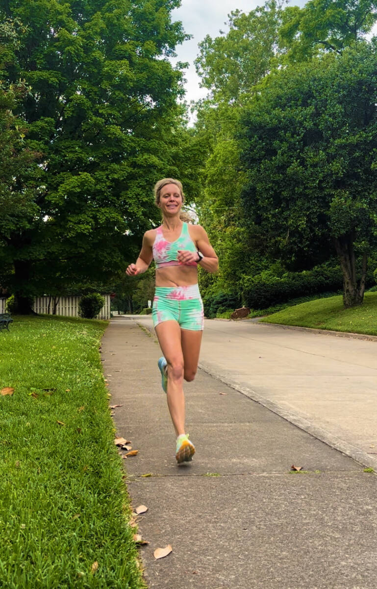 Whitney Heins running in tie dye sports bra and spandex shorts