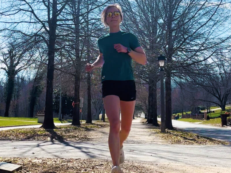 runner in green top on gravel path