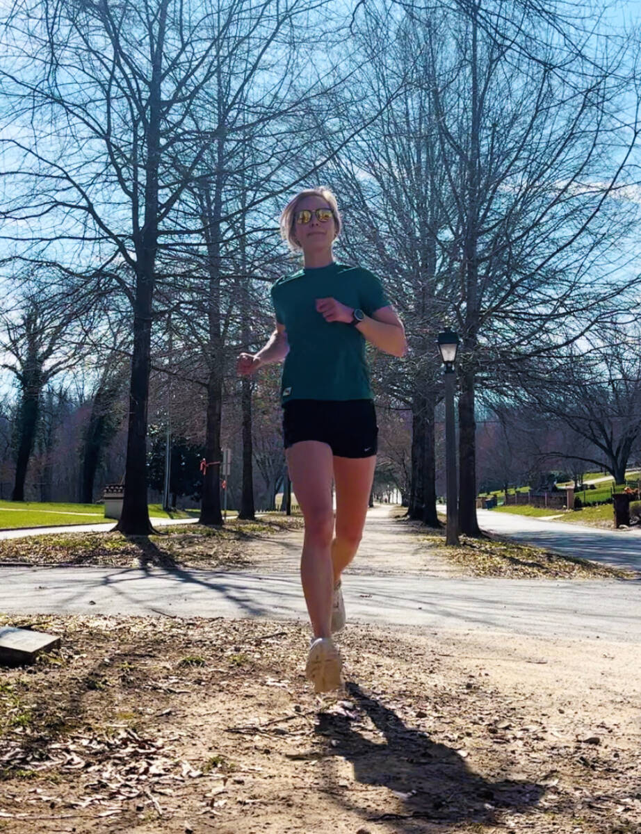 runner in green top on gravel path