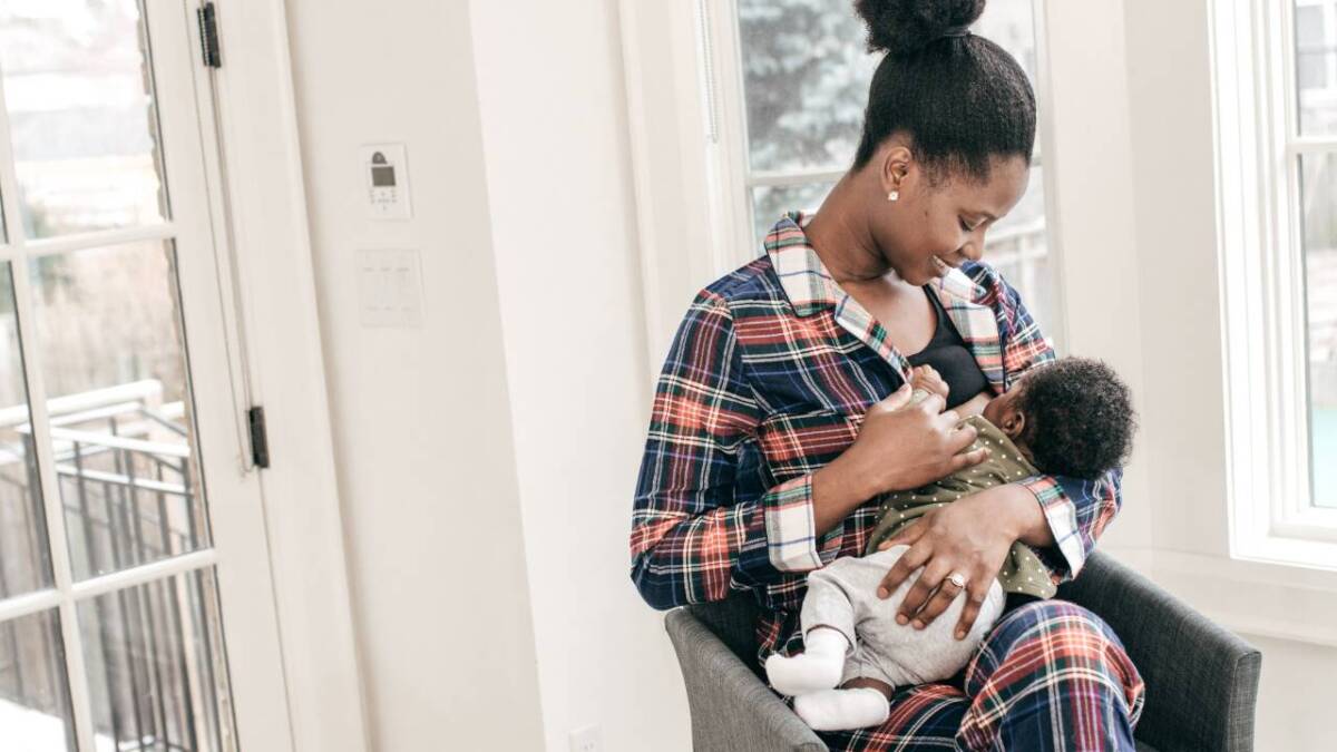 woman breastfeeding baby in flannel robe