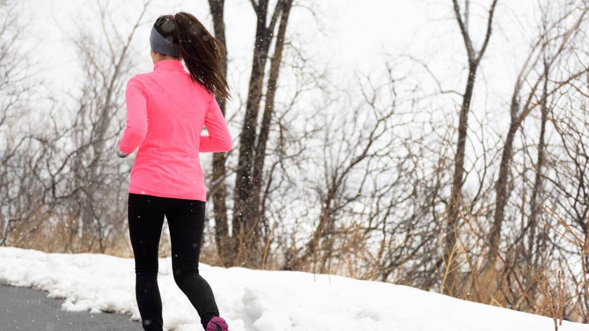 woman in pink running in snow