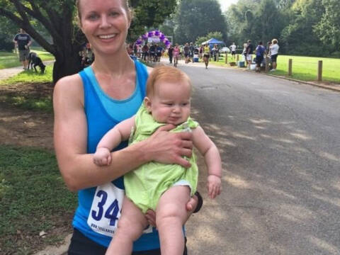 woman runner holding baby