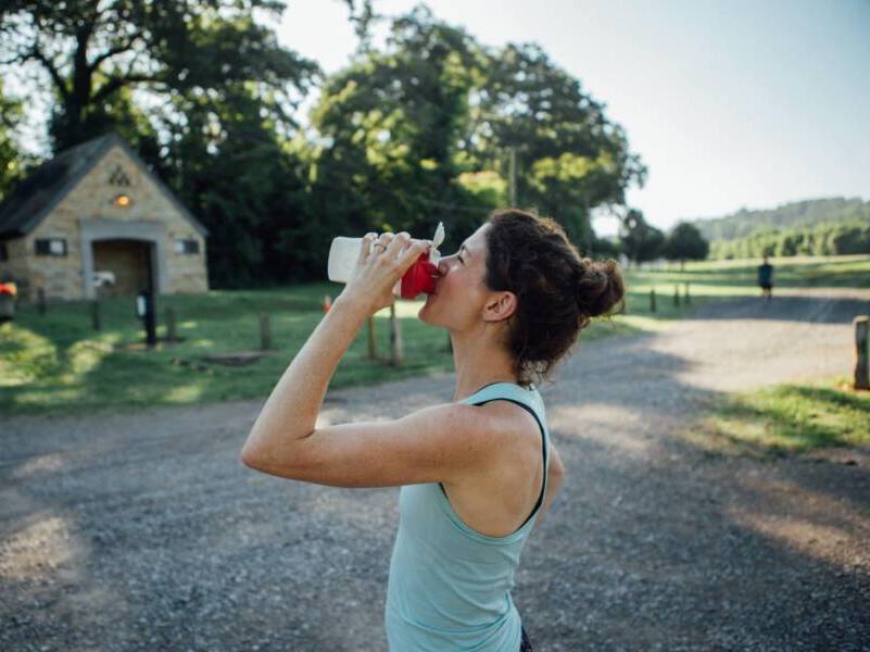 Woman drinking from a sports water bottle.