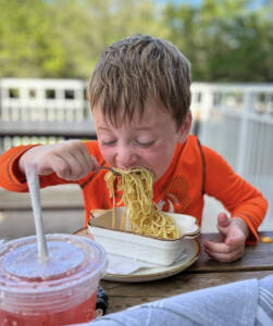 child eating a bowl of pasta