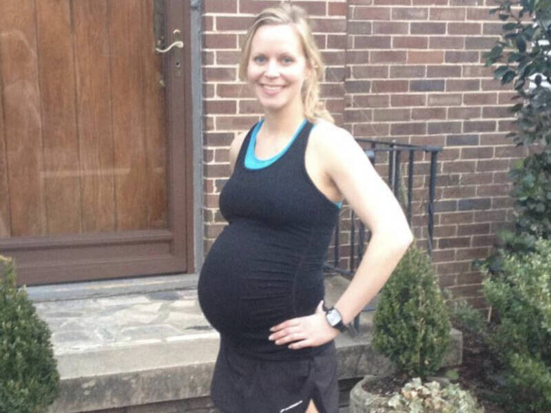 Pregnant woman in black with running shoes on.