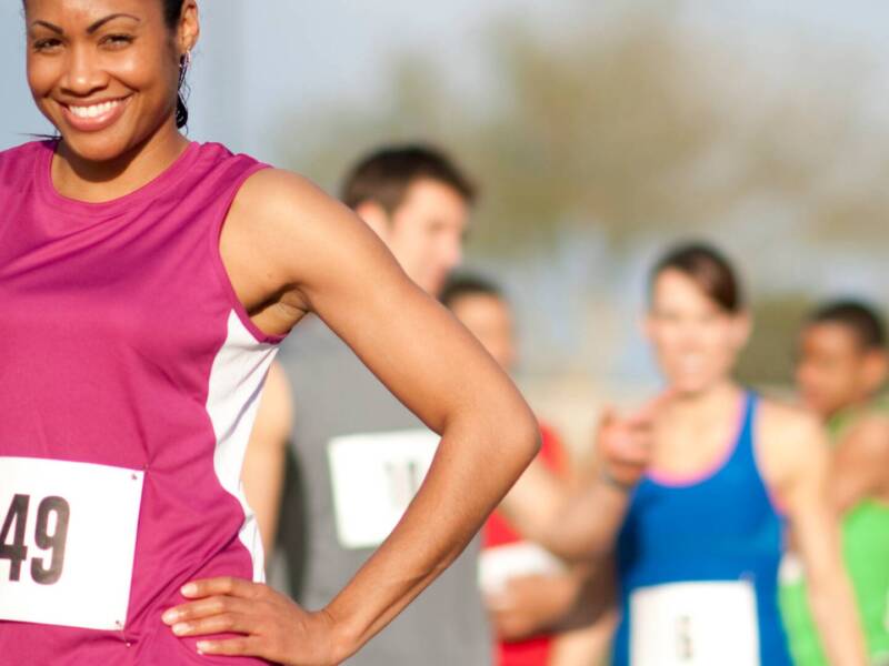 women runner in pin with race bib smiling