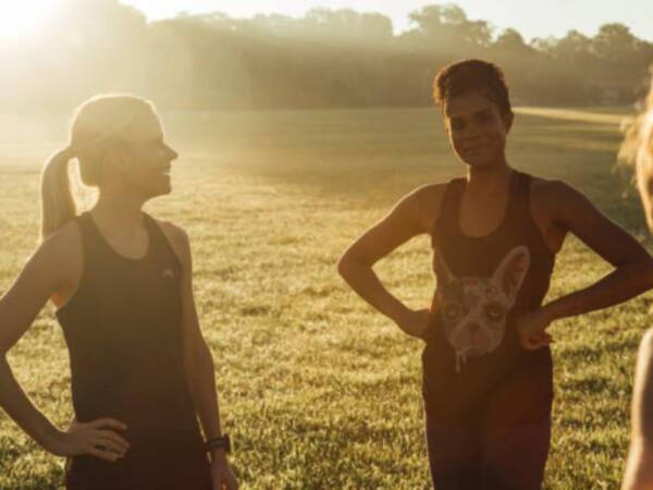 women in a field talking in running clothes