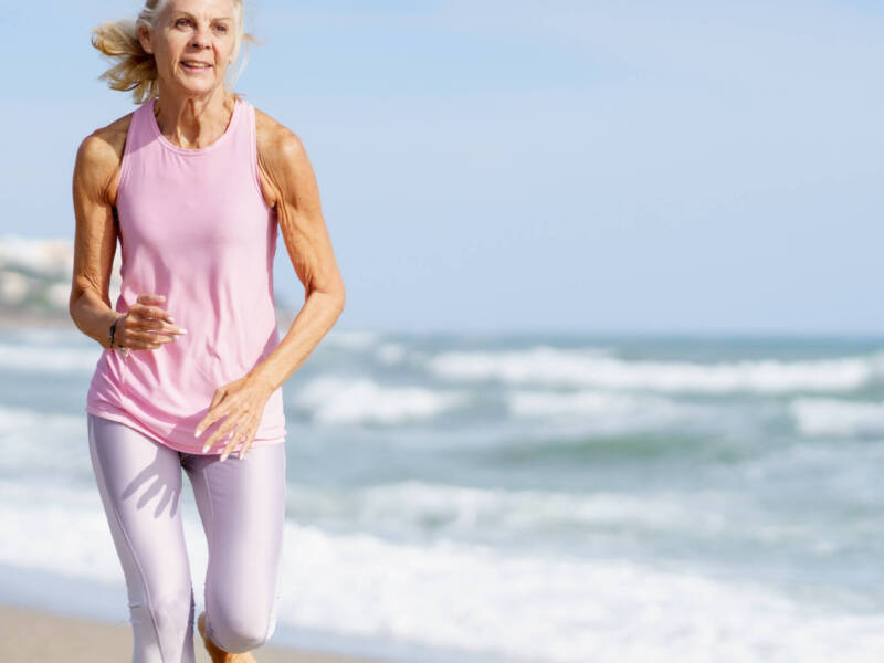 older woman running on the beach