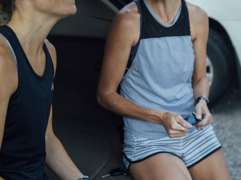 women eating on tailgate of car