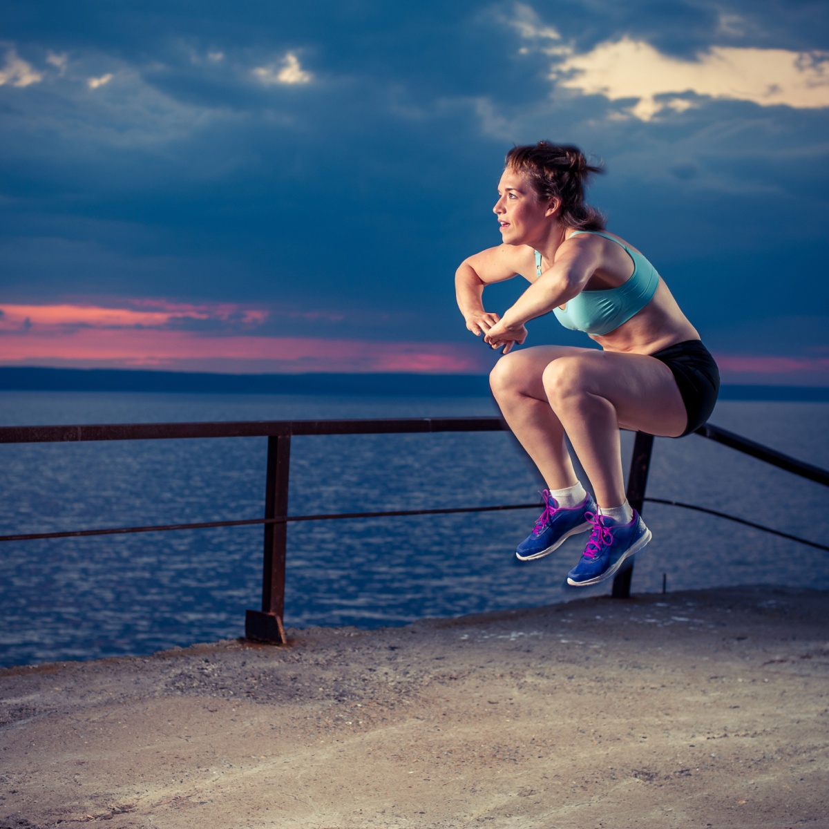 female runner doing plyometric jump