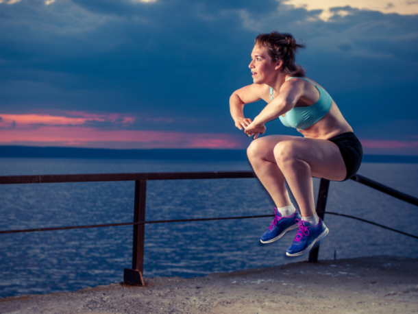 female runner doing plyometric jump